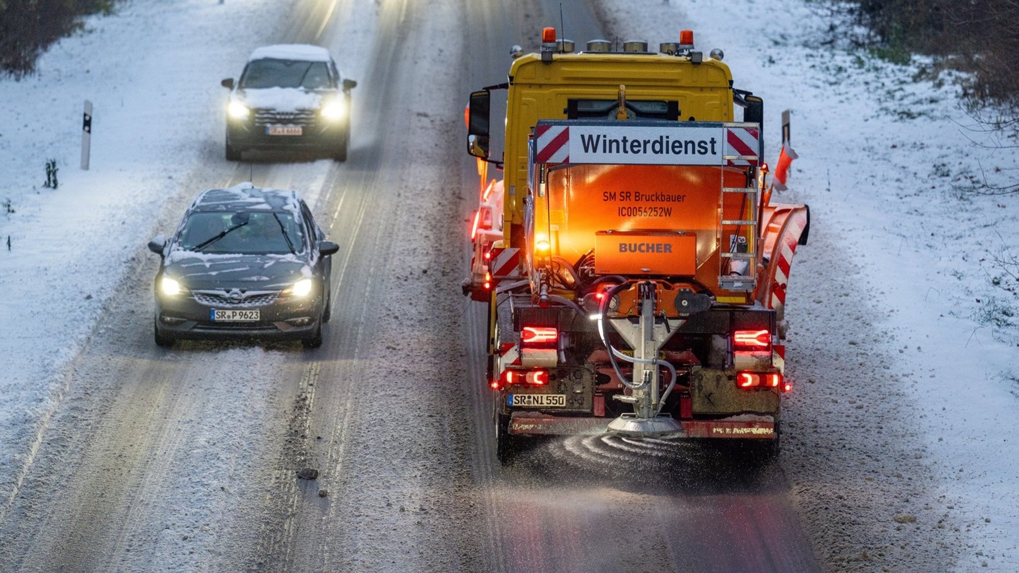 Winterdienst fährt auf der mit Schnee bedeckten Bundesstraße 8