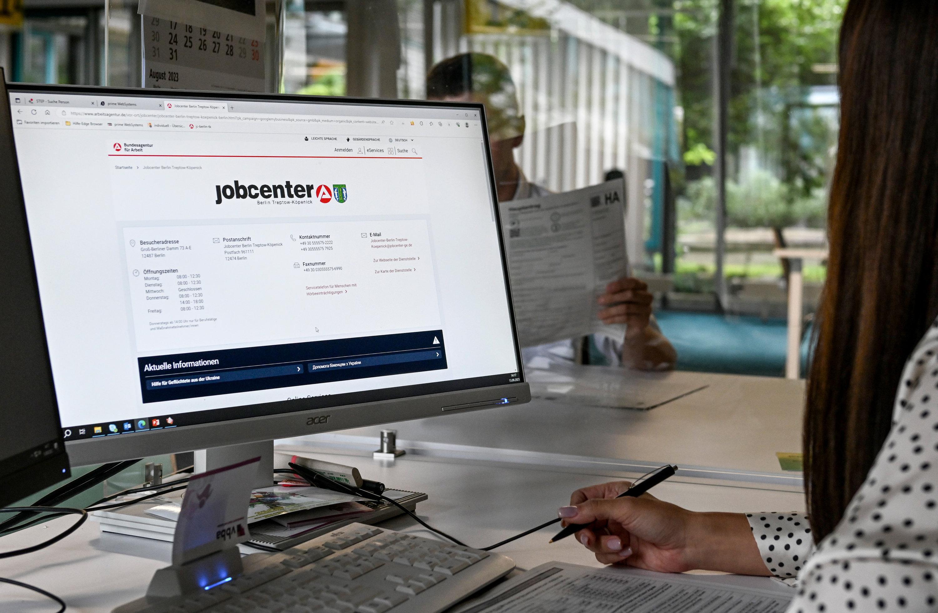 Eine Frau sitzt an einem Computer mit Informationen zum Jobcenter. | Bild:dpa-Bildfunk/Jens Kalaene