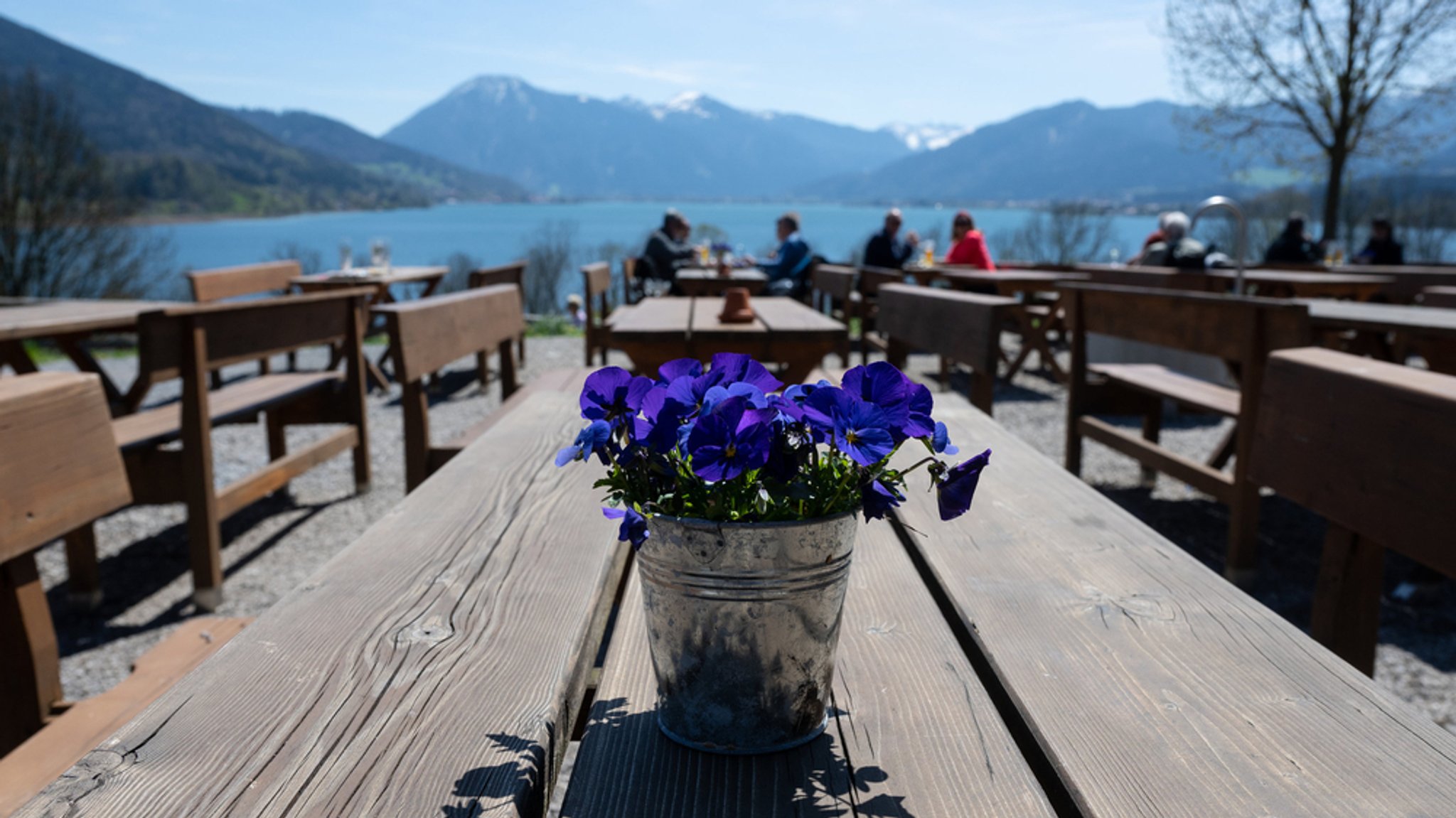 Ausflüger sitzen bei schönem Wetter in einem Biergarten am Tegernsee (Archivbild vom 4.5.23)