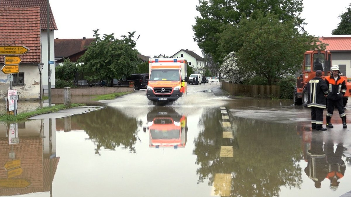 Ein Krankenwagen fährt über eine überschwemmte Straße in Pfaffenhofen an der Ilm.