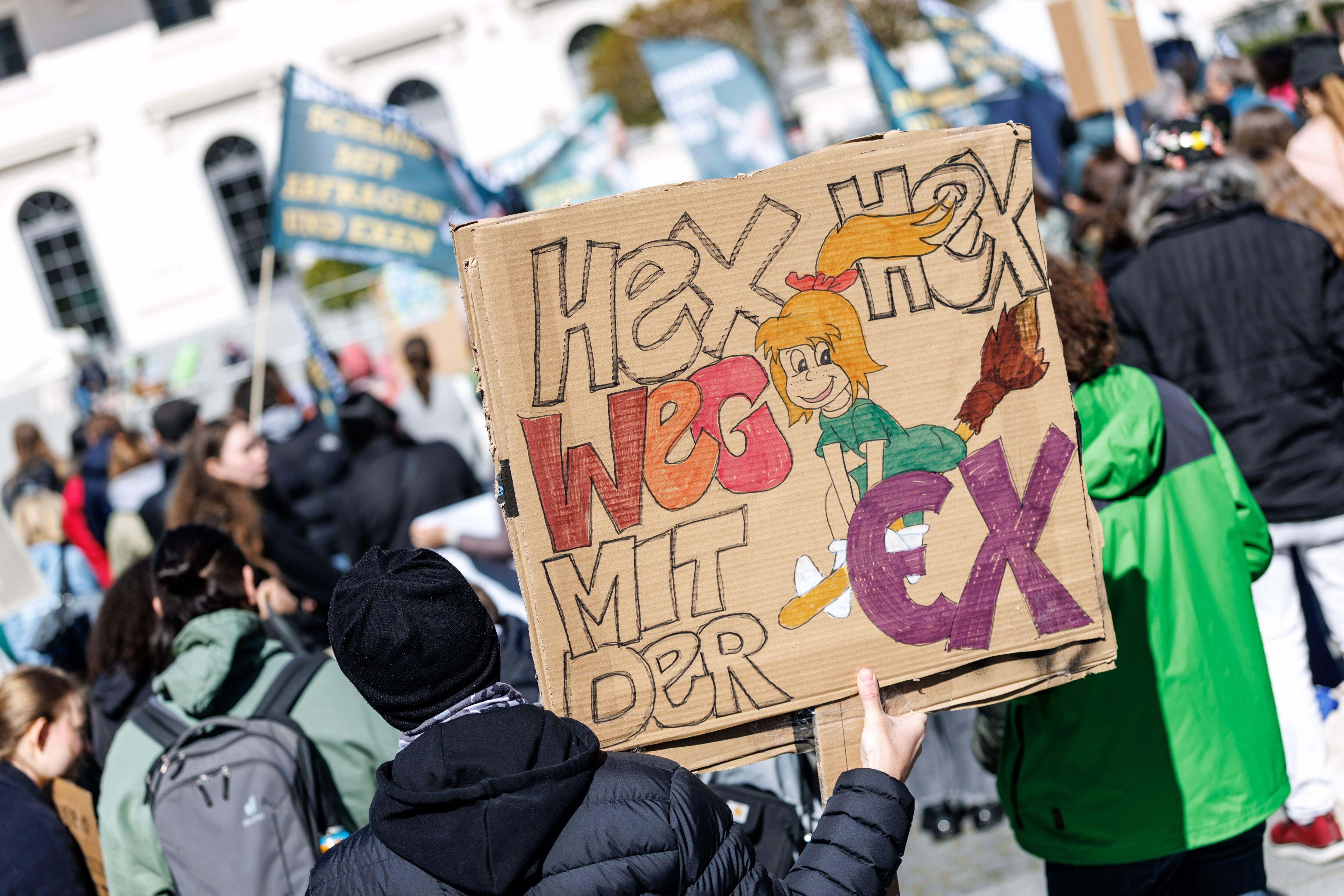 Archivbild: Ein Teilnehmer einer Demonstration steht mit einem Schild mit der Aufschrift "Hex hex, weg mit der Ex" in München