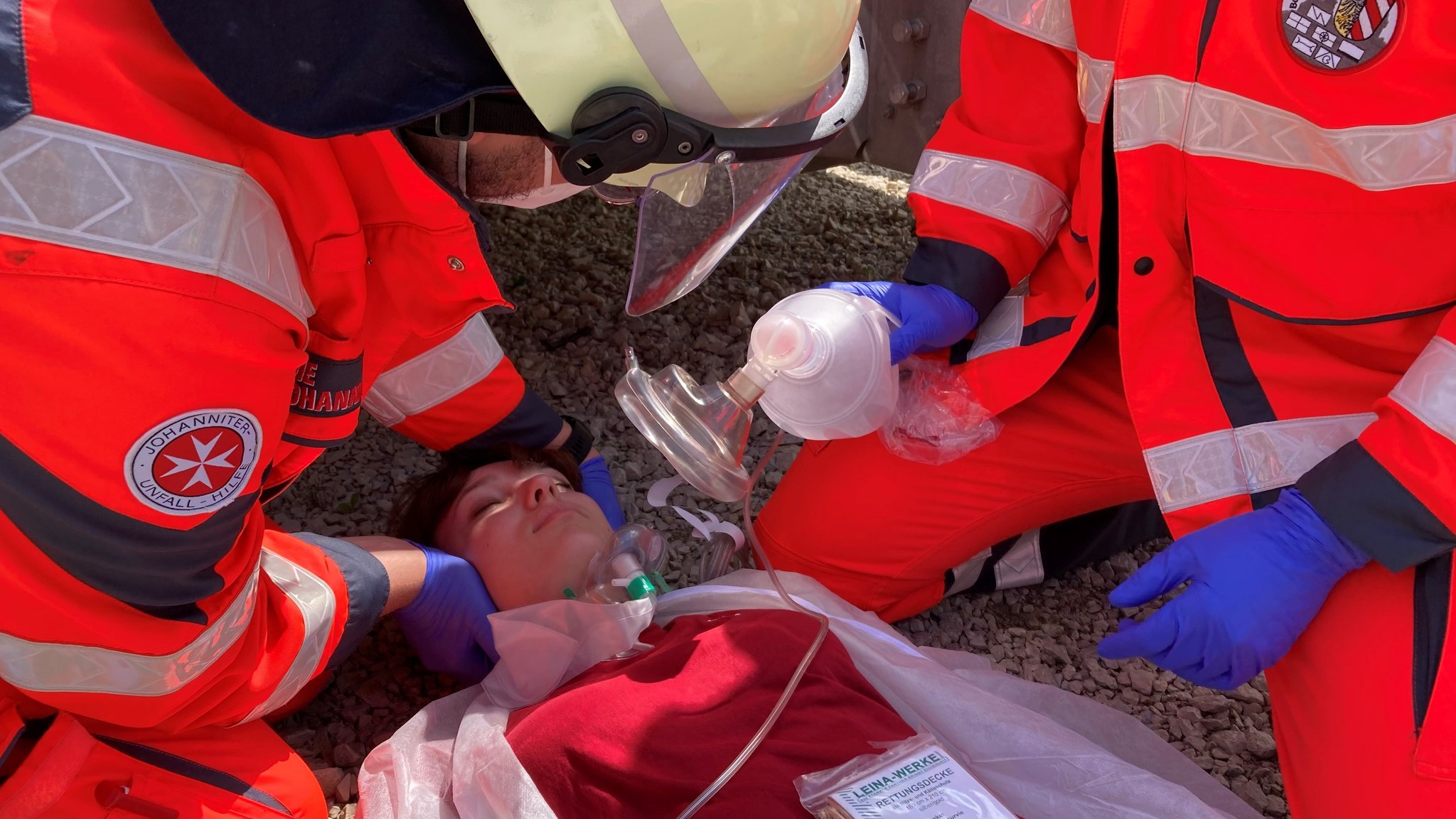 Zwei Notfallsanitäter üben die Beatmung einer Person an einer Puppe.