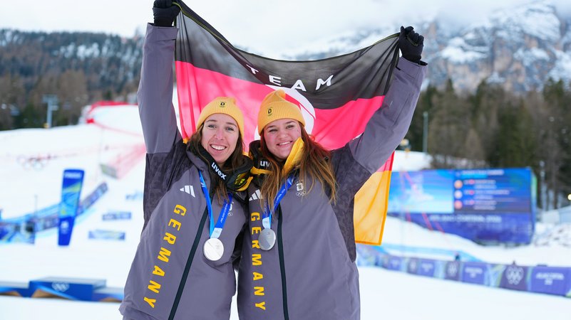 Kira Weidle-Winkelmann (l.) und Emma Aicher (r.) jubeln mit ihren Silbermedaillen über den zweiten Platz bei Olympia 2026. | Bild: pa/dpa/Michael Kappeler Kira Weidle-Winkelmann (l.) und Emma Aicher (r.) jubeln mit ihren Silbermedaillen über den zweiten Platz bei Olympia 2026.