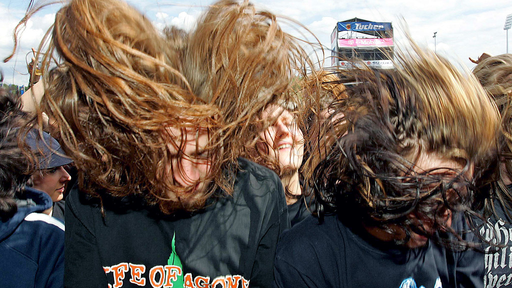 Metallfans schütteln ihre Haare bei einem Festival: sie "headbangen"