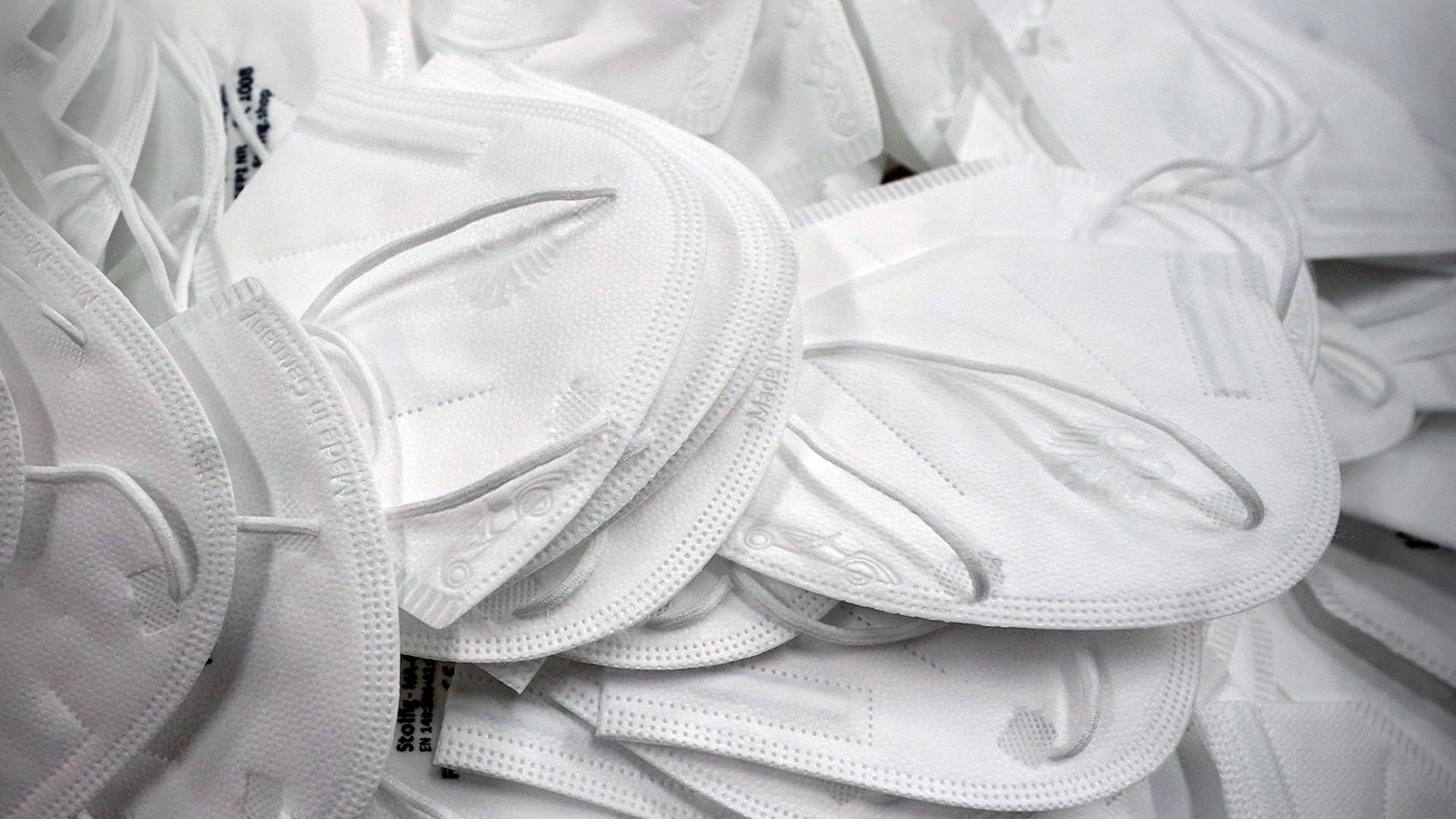 Symbolbild: Masken liegen auf einem Haufen 