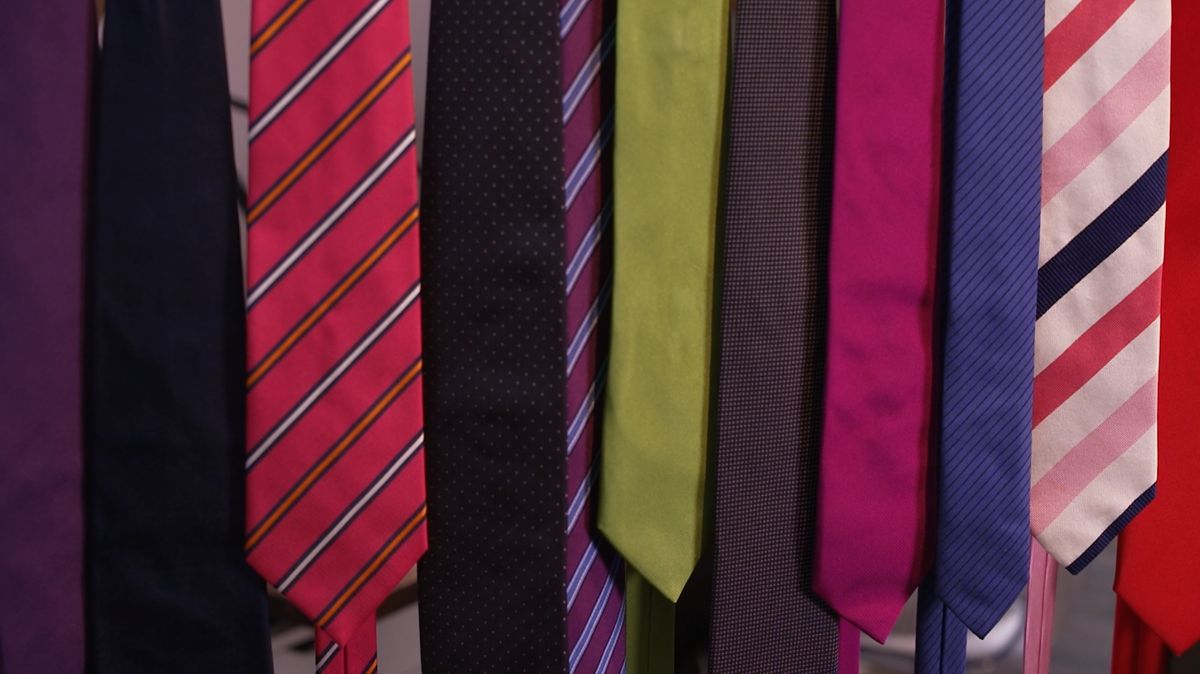 Mehrere Krawatten hängen in einer Reihe.