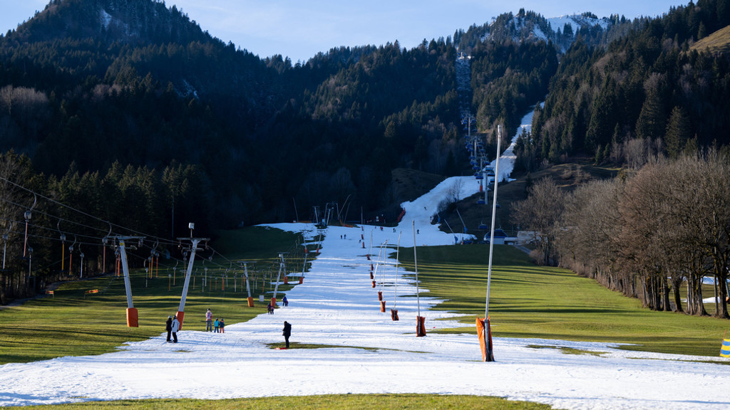 Der Draxlhang im Skigebiet Brauneck: Ein wenige Meter schmales Schneeband zieht sich einen ansonsten grünen Hang hinauf. Am linken Rand stehen die Schlepplift-, am rechten Rand die Flutlicht-Masten.
