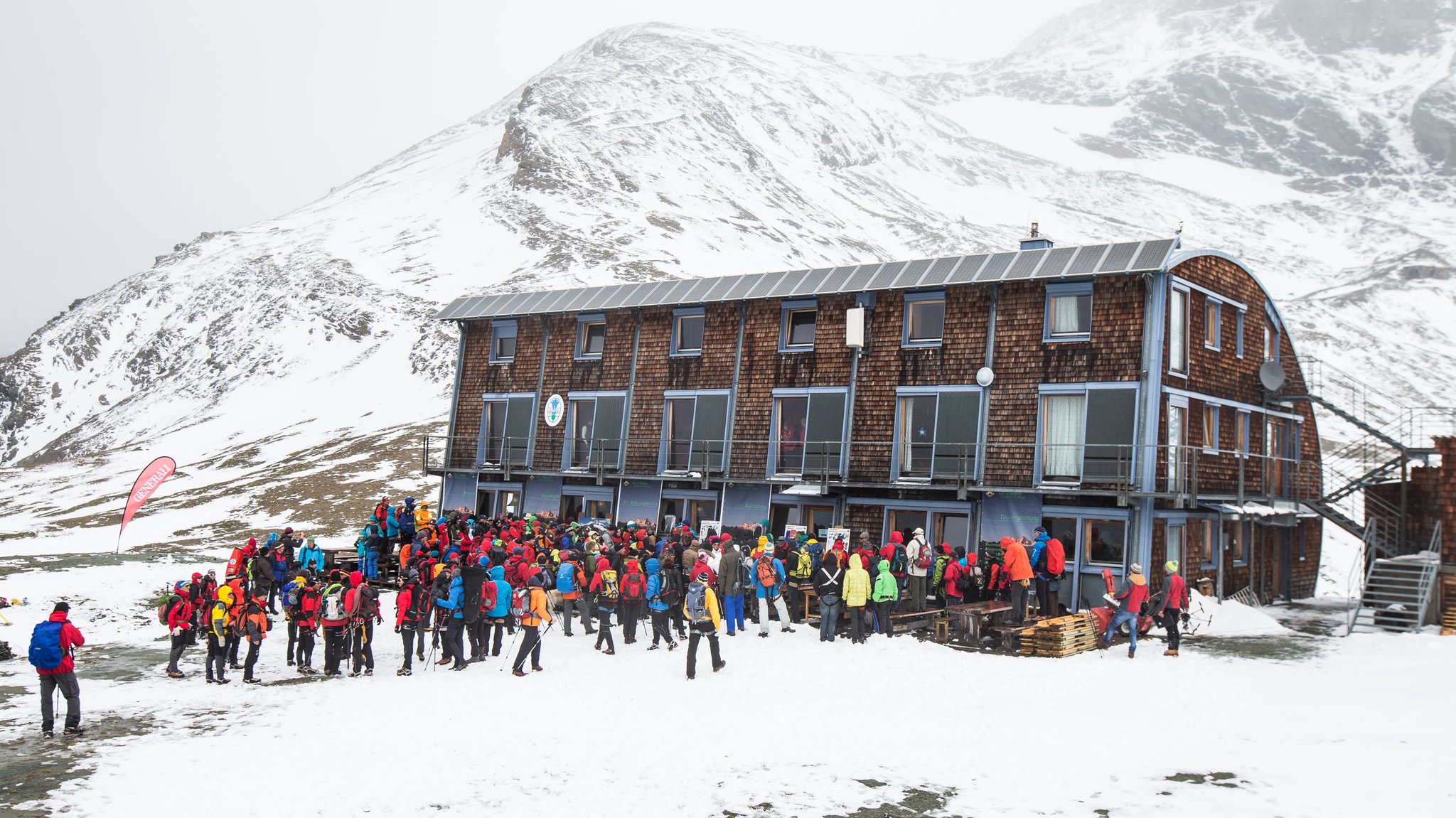 Viele Menschen vor der Stüdlhütte, es liegt Schnee