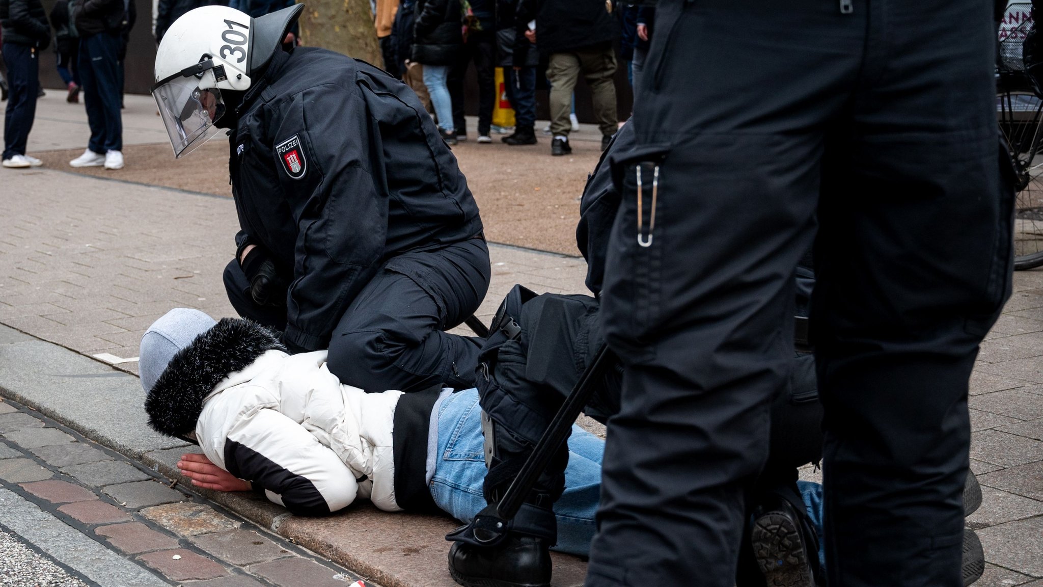 Symbolbild: Ein Polizist hält einen Jugendlichen fest.