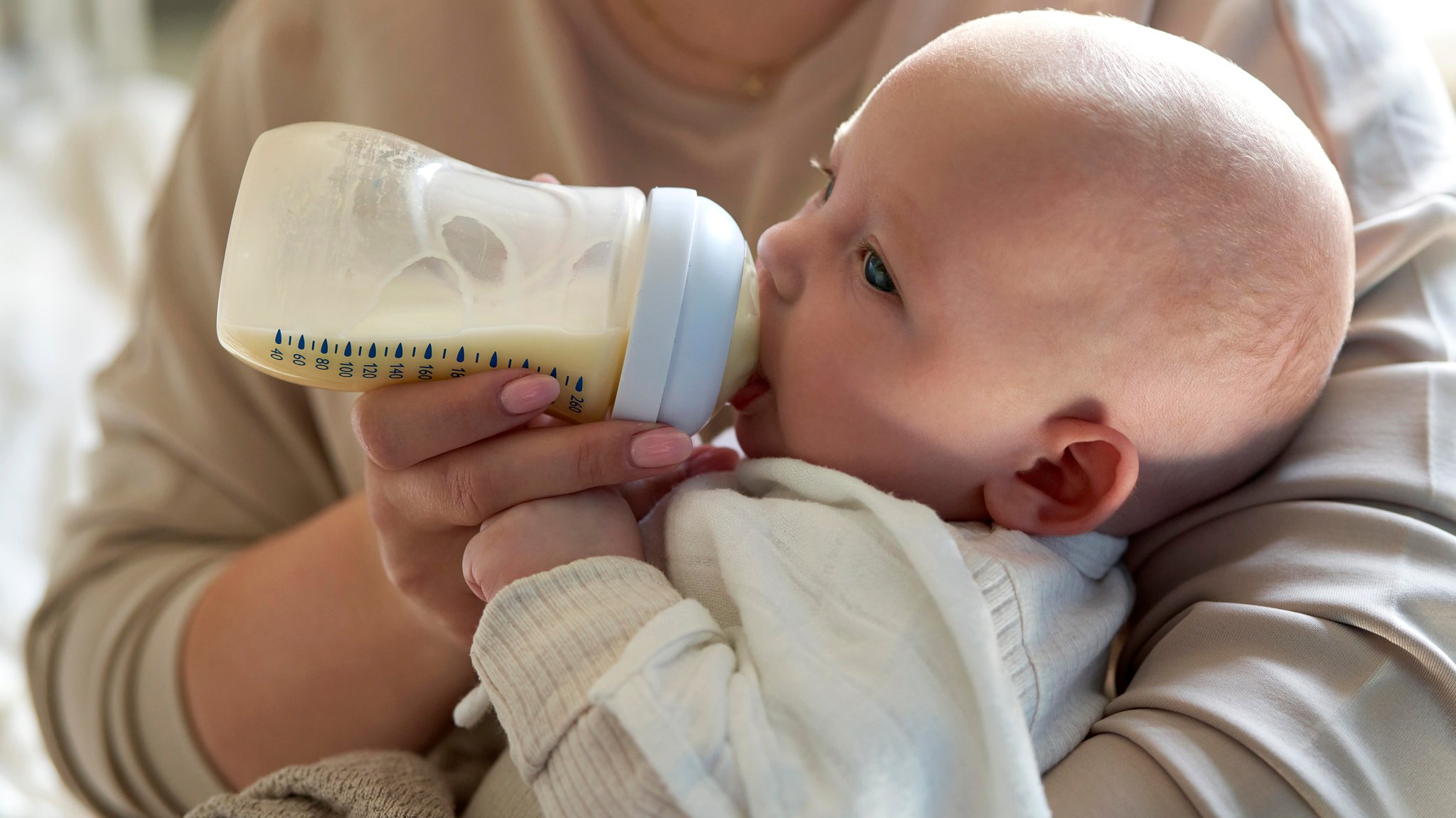 Eine Mutter füttert ihr Baby mit dem Fläschchen (Symbolbild).