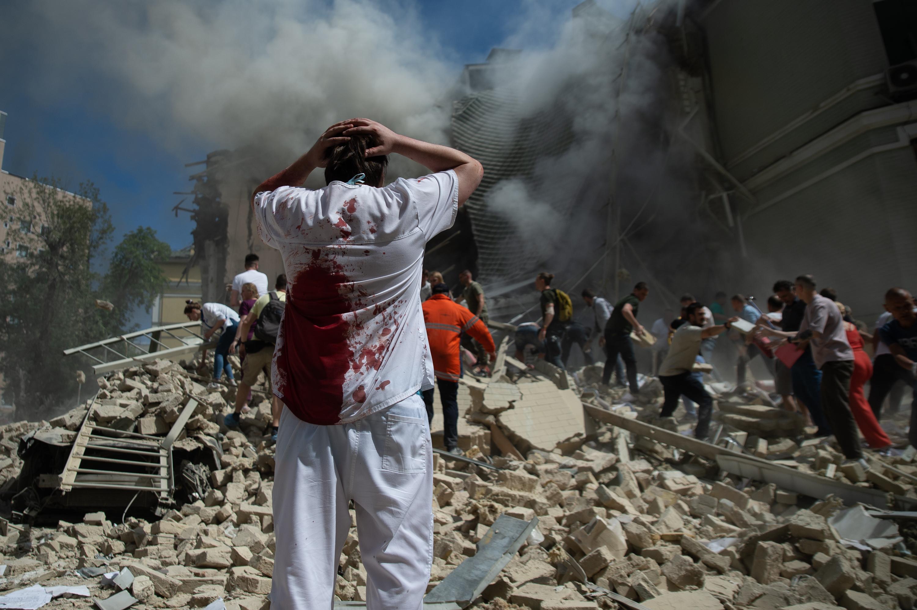 Kiew, 08.07.24: Ein verletzter Krankenhausmitarbeiter vor den Trümmern eines zerstörten Kinderkrankenhauses.