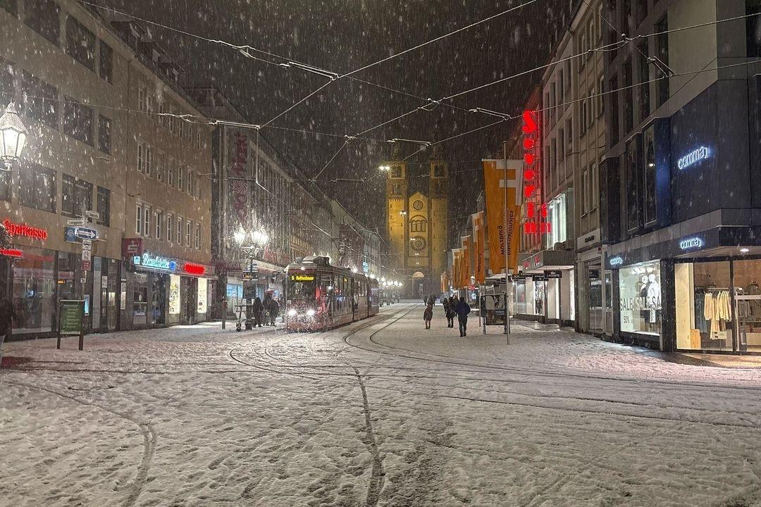 25.01.2026, Bayern, Würzburg: Verschneit ist die Innenstadt von Würzburg am Sonntagabend. Der Deutsche Wetterdienst warnt vor glatten Straßen. 