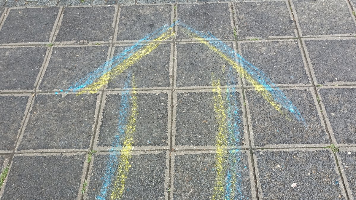 Blau-gelber Pfeil auf einem Bürgersteig