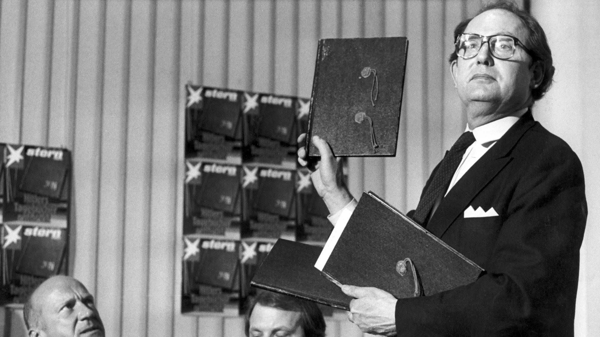 (Archivbild) "Stern"-Reporter Gerd Heidemann (r) zeigt am 25.04.1983 in Hamburg auf einer Pressekonferenz die vermeintlichen Hitler-Tagebücher