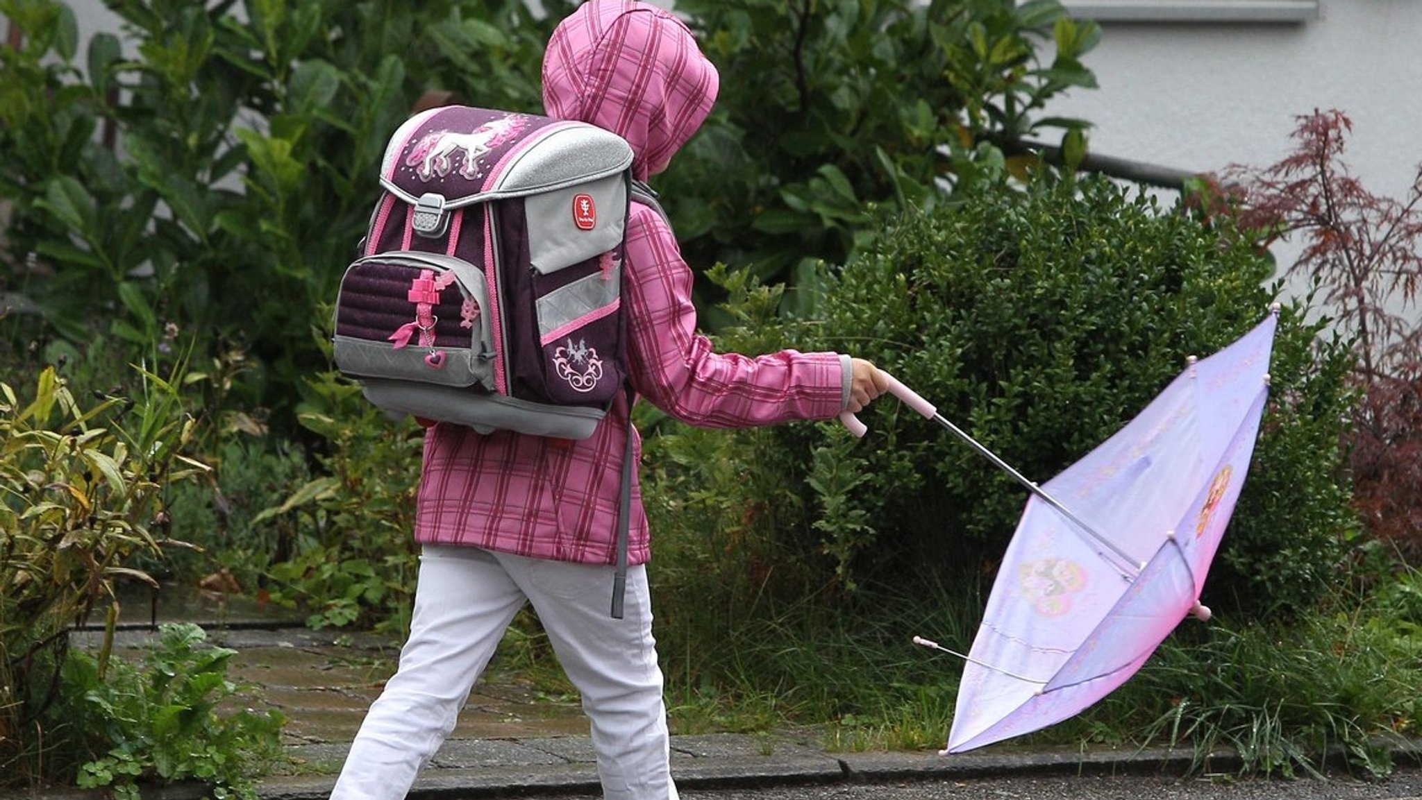 Schulkind im Regen