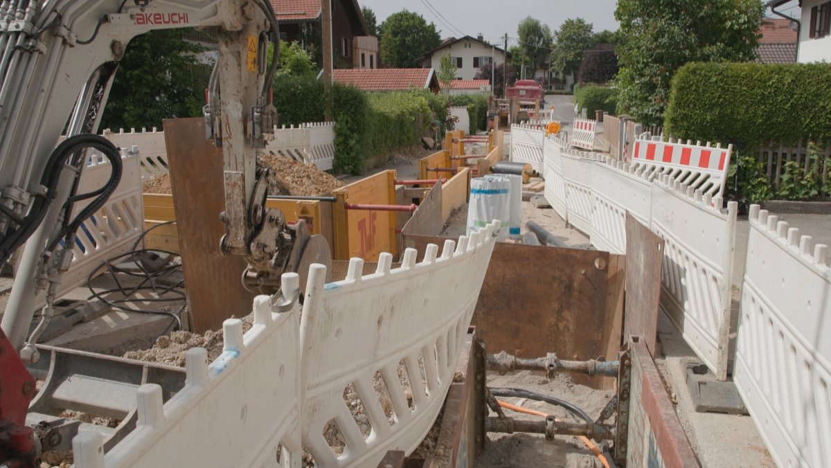 Wasserrohre für das Fernwärmenetz werden in einer Straße im oberbayerischen Holzkirchen verlegt.