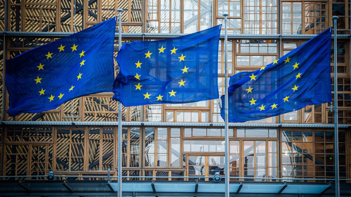 laggen der Europäischen Union wehen im Wind vor dem Europa-Gebäude.
