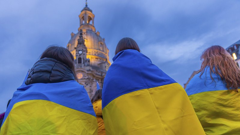 Drei Frauen demonstrieren, in eine Ukraine-Flagge gehüllt. (Archivbild) | Bild: pa/dpa/ imageBROKER | Sylvio Dittrich Drei Frauen demonstrieren, in eine Ukraine-Flagge gehüllt. (Archivbild)