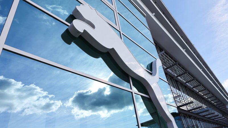 Wolken spiegeln sich im Fenster hinter einem Puma-Logo am Firmensitz des Sportartikelherstellers in Herzogenaurach | Bild: dpa-Bildfunk/Daniel Löb Wolken spiegeln sich im Fenster hinter einem Puma-Logo am Firmensitz des Sportartikelherstellers in Herzogenaurach