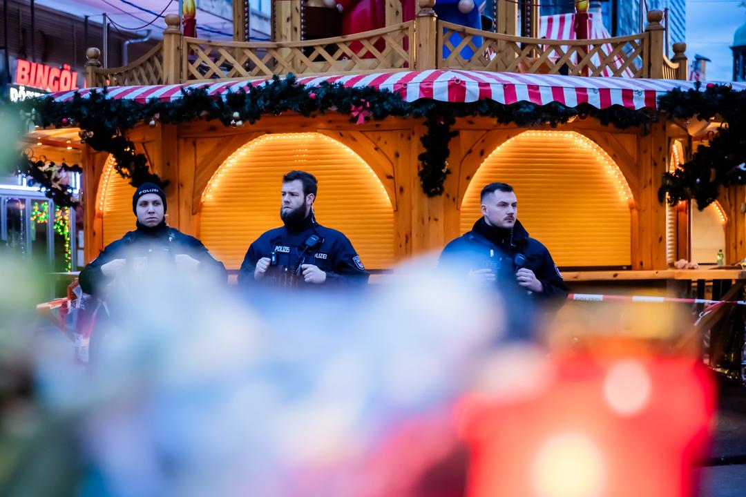 drei bewaffnete Polizisten stehen in Magdeburg vor der Weihnachtspyramide. Einer der Toten nach der Attacke auf den Weihnachtsmarkt in Magdeburg ist ein neunjähriger Bub aus Bayern.