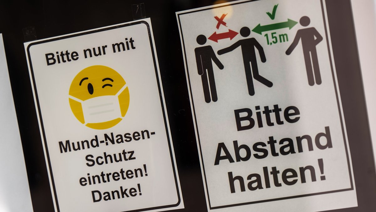 Bayern, Rosenheim: Hinweise mit der Aufschrift «Bitte nur mit Mund-Nasen-Schutz eintreten! Danke!«, und »Bitte Abstand halten!», kleben in der Tür eines Ladengeschäfts in der Innenstadt. 