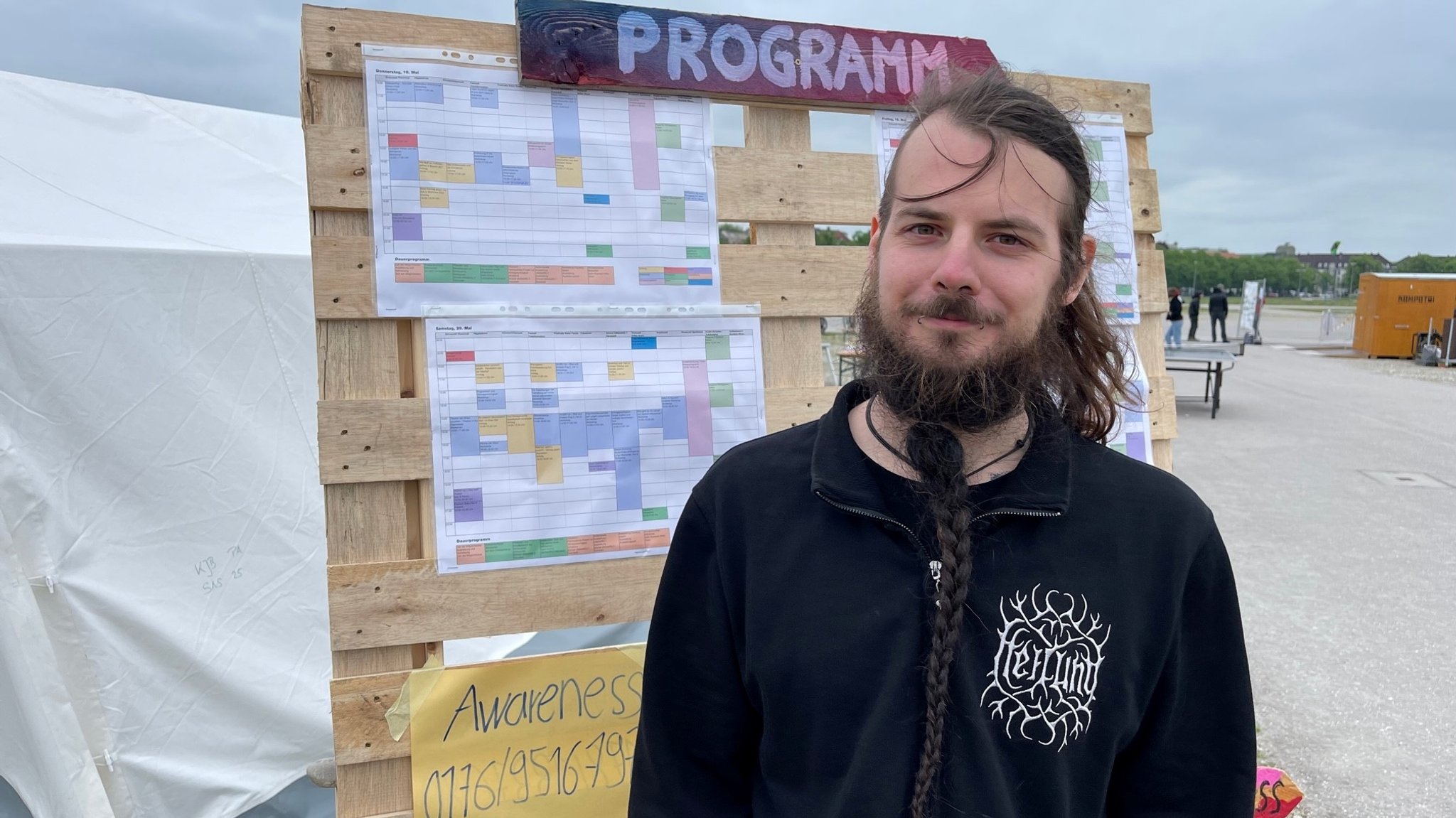 Joschua (26) vor der Programmtafel interessiert sich für den Workshop "Wie die Klimabewegung inklusiver wird"