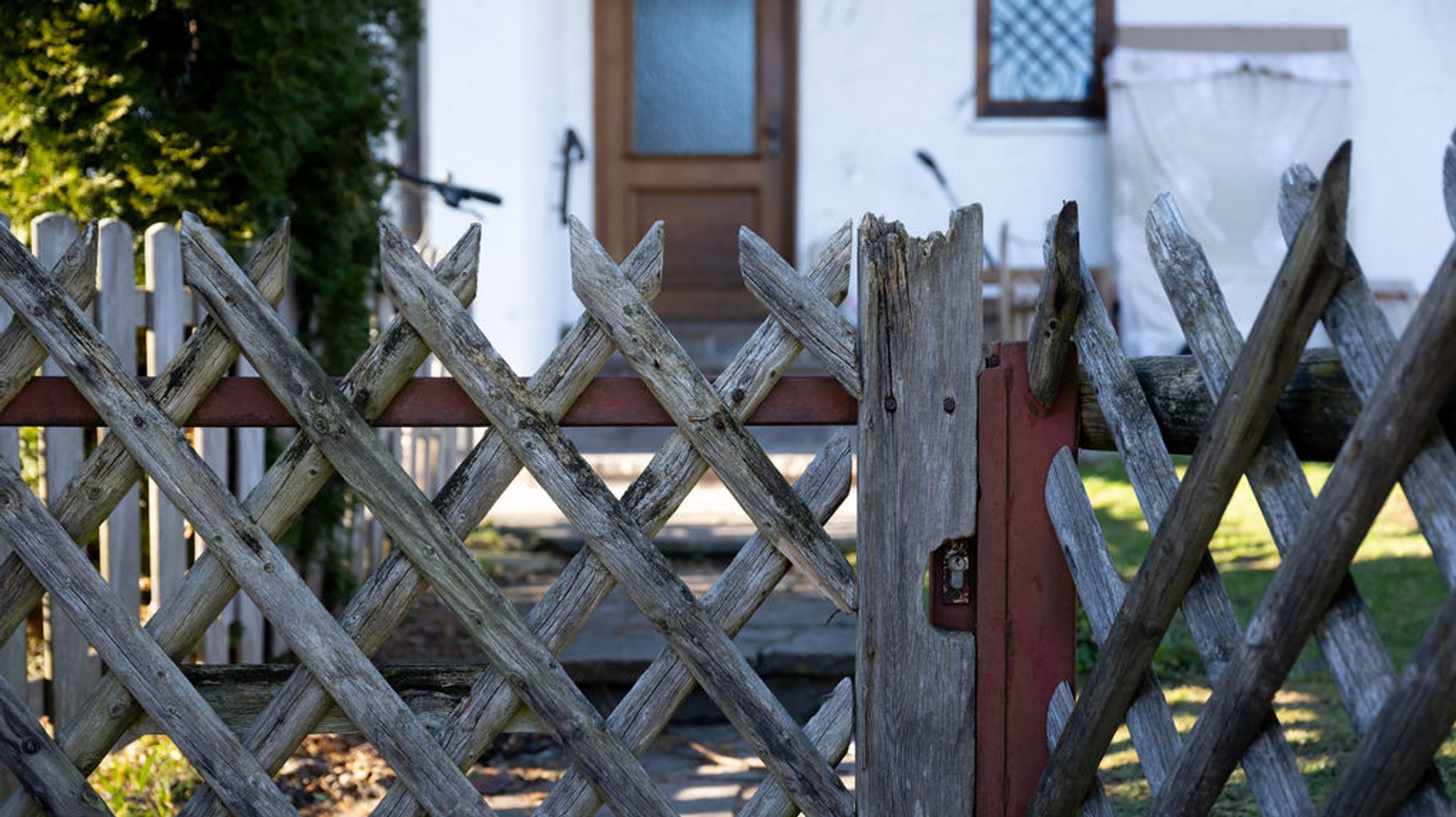 25.12.2024, Bayern, Rosenheim: Ein Jägerzaun steht vor einem Wohnhaus. In dem Haus sind am ersten Weihnachtsfeiertag die Leichen zweier Kinder und ihre verletzte Mutter gefunden worden. Die Ermittler gingen zunächst davon aus, dass die Frau ihre sechs und sieben Jahre alten Kinder an Heiligabend oder in der Nacht mit einem Werkzeug tödlich verletzte. Anschließend soll sie versucht haben, sich selbst zu töten. Foto: Sven Hoppe/dpa +++ dpa-Bildfunk +++