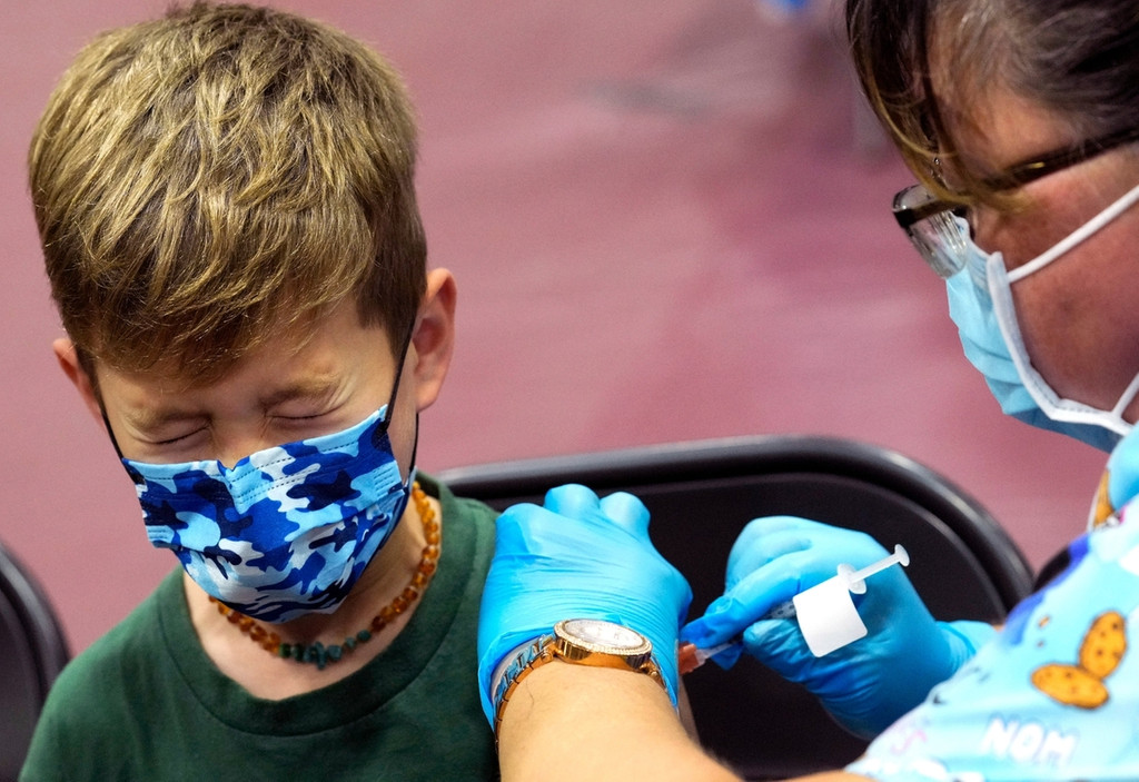 Ein siebenjähriger Junge wird von einer Frau mit einem Covid-19-Impfstoff geimpft. Die Impfung fand während eines Termins zur Einführung von Coronavirus-Impfungen für Kinder zwischen fünf und elf Jahren statt.