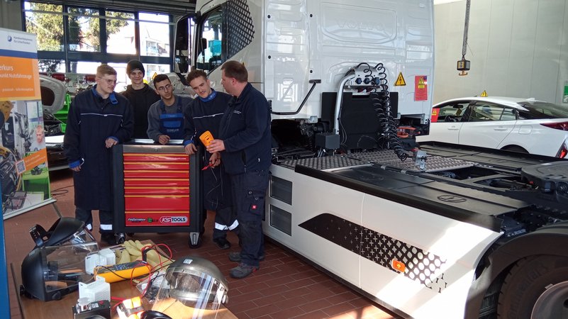 Ausbilder Sebastian Barth weist seine Azubis am E-Lkw in einer Werkstatt der Fahrzeugakademie Schweinfurt ein. | Bild: Ralph Wege Ausbilder Sebastian Barth weist seine Azubis am E-Lkw in einer Werkstatt der Fahrzeugakademie Schweinfurt ein.