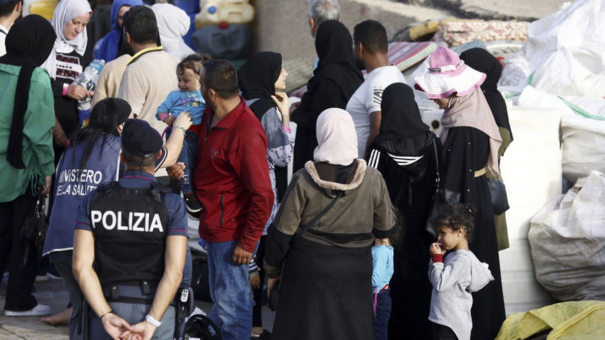 18.09.2023, Italien, Lampedusa: Im Hafen der Insel Lampedusa wird gerade angekommenen Migranten geholfen. Die Ankunft Tausender Bootsmigranten in kurzer Zeit hat die Insel Lampedusa an ihre Grenzen gebracht. Italiens Kabinett will nun ein härteres Vorgehen gegen Migration beschließen. Foto: Cecilia Fabiano/LaPresse/AP/dpa +++ dpa-Bildfunk +++