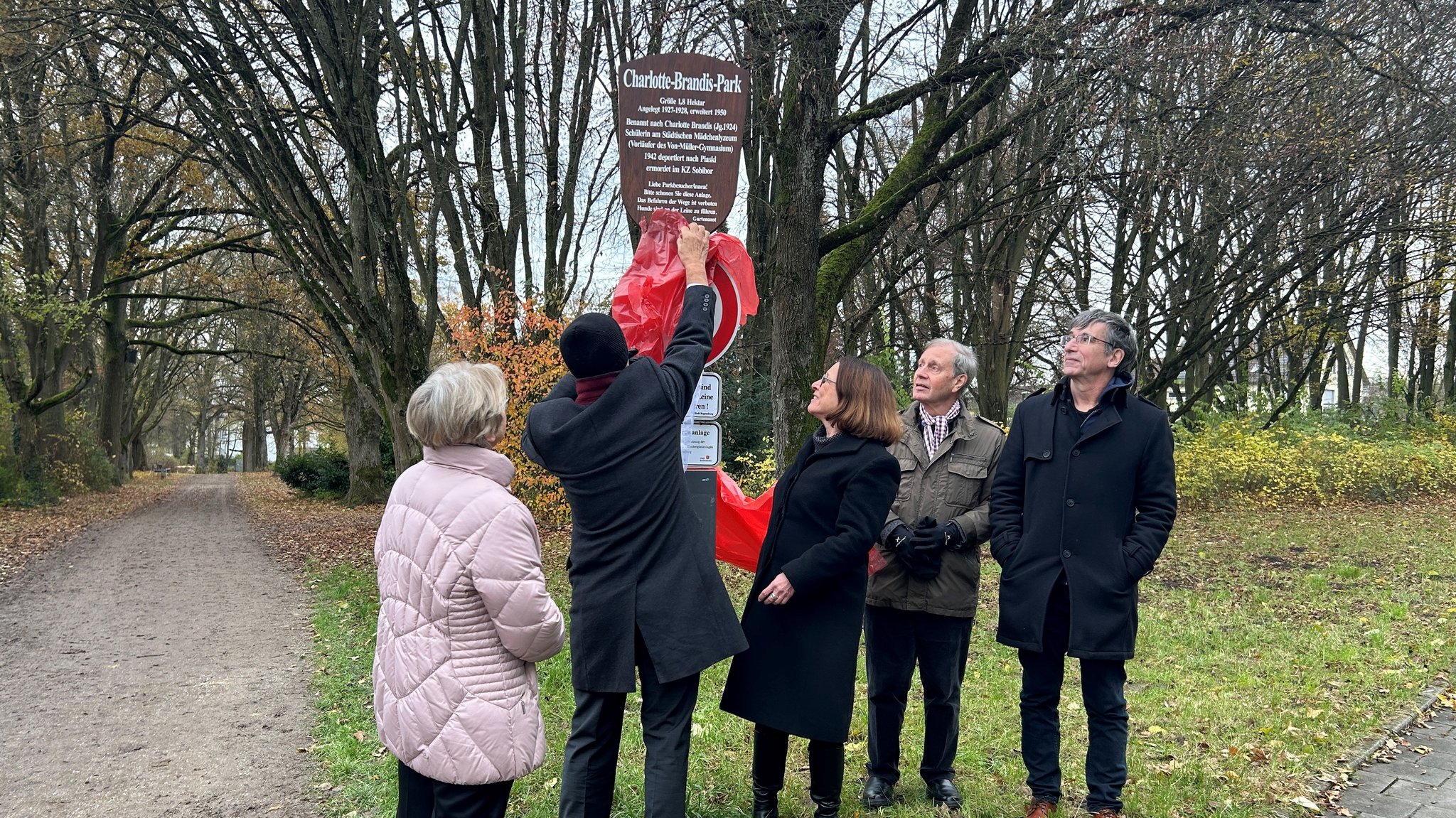 Enthüllung des Schildes im Charlotte-Brandis-Park. 