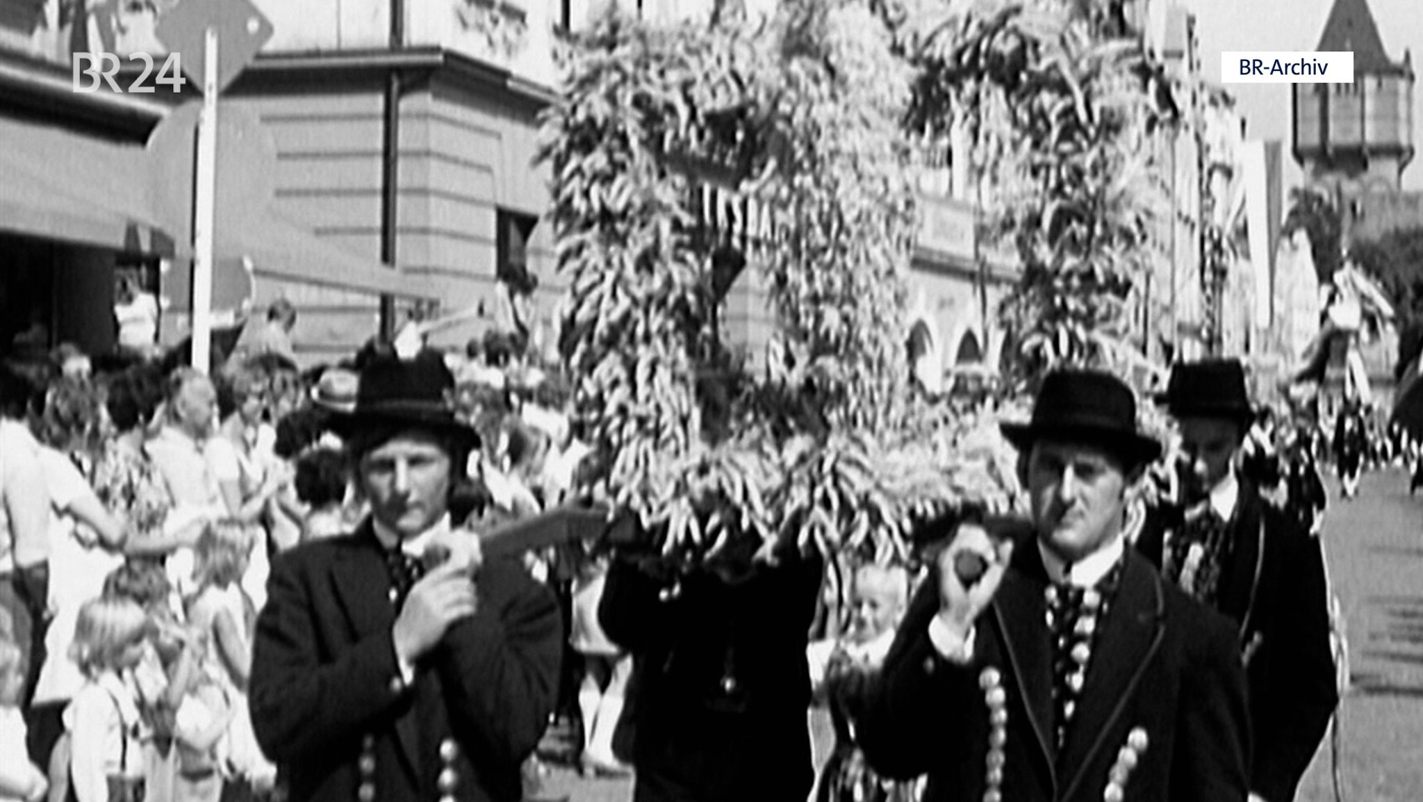 Auszug mit Erntekrone, die von mehreren Männern getragen wird.