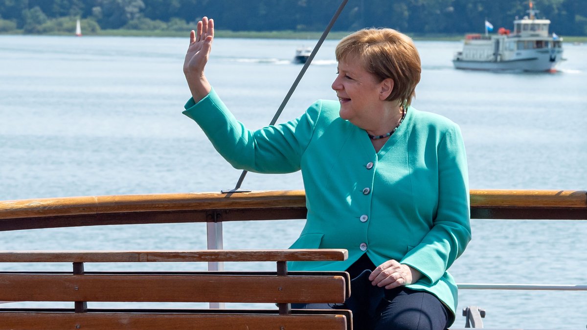 Angela Merkel fährt mit einem Schiff der Chiemsee-Schifffahrt auf die Insel Herrenchiemsee und winkt (Archivfoto).