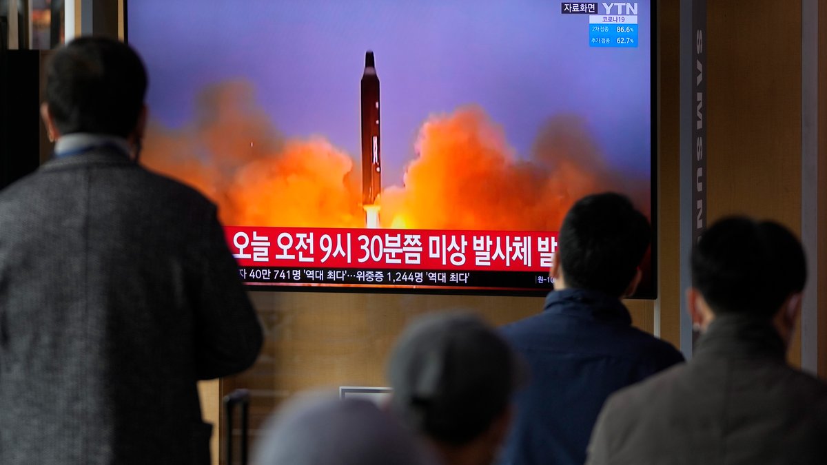 Archiv: Menschen schauen am 16.3.2022 auf einen Fernsehbildschirm, auf dem eine Nachrichtensendung mit Filmmaterial über Nordkoreas Rakete gezeigt wird, in einem Bahnhof in Seoul, Südkorea.