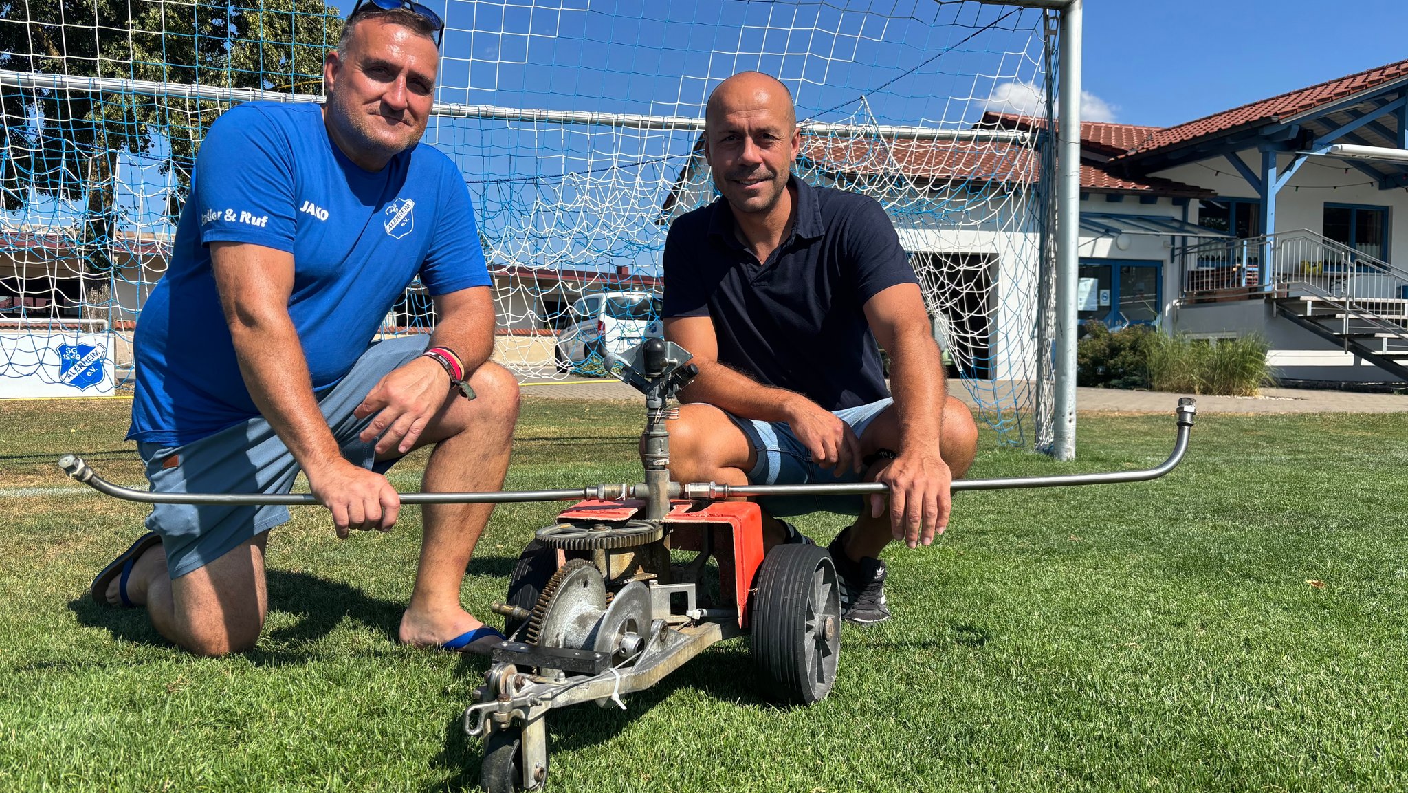 Kurt Sandl und Benjamin Töpfer vom SG Alerheim vor dem kaputten Bewässerungswagen.