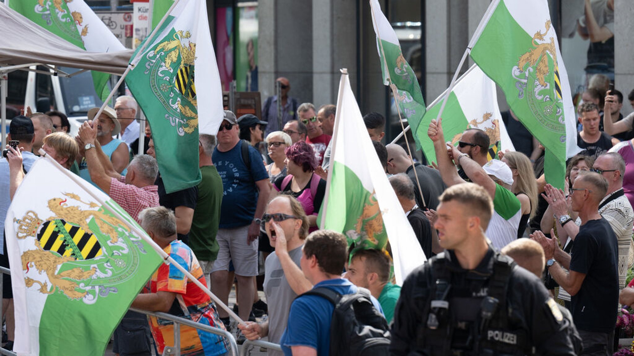 30.08.2024, Sachsen, Chemnitz: Teilnehmer einer Protestkundgebung der Partei "Freie Sachsen" stehen am Rande des Wahlkampfabschlusses der SPD in Chemnitz. Am 1. September finden in Sachsen die Landtagswahlen statt. Foto: Hendrik Schmidt/dpa +++ dpa-Bildfunk +++