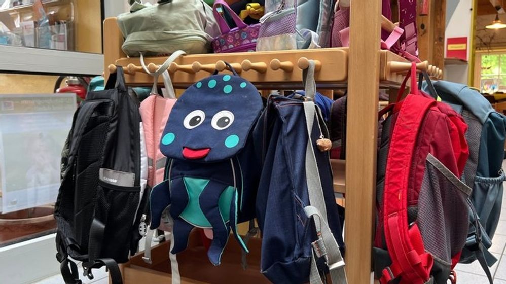 Bunte Kinderrucksäcke hängen in der Garderobe des Kindergartens "Zum Regenbogen" in Willing  | Bild:BR/Julia Binder