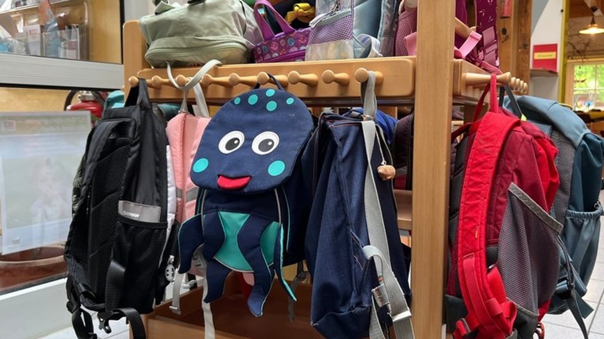 Bunte Kinderrucksäcke hängen in der Garderobe des Kindergartens "Zum Regenbogen" in Willing 