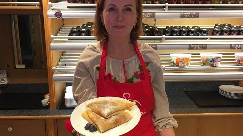 Oksana Bammaieva zeigt einen Teller mit Pfannkuchen.