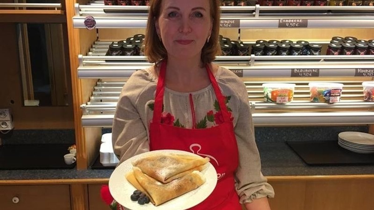 Oksana Bammaieva zeigt einen Teller mit Pfannkuchen.