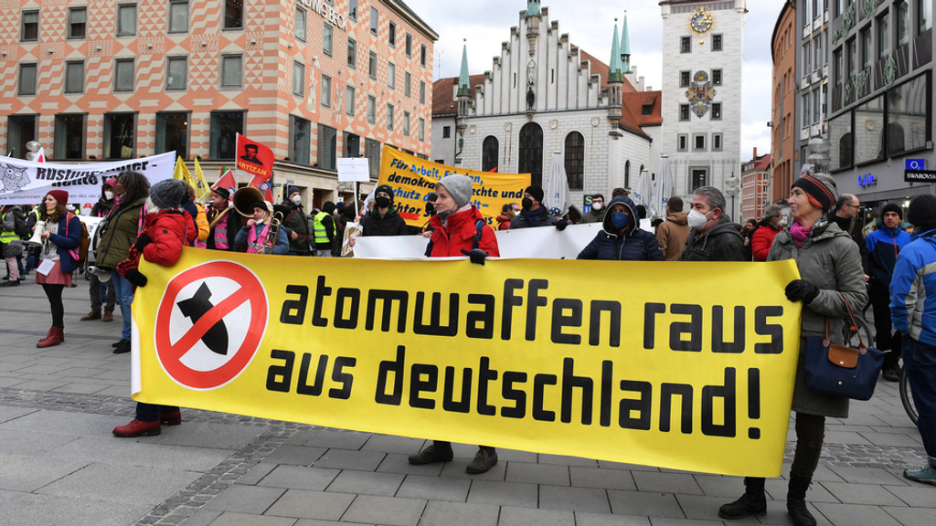 Demonstranten stehen bei einer Demo gegen die Sicherheitskonferenz auf dem Marienplatz mit einem Plakat mit der Aufschrift "Atomwaffen raus aus Deutschland". 