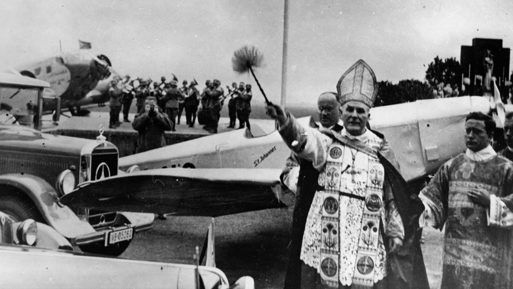 Der Münchner Erzbischof und Kardinal Michael Faulhaber weiht Missionsfahrzeuge am Flughafen München. Um 1935.
