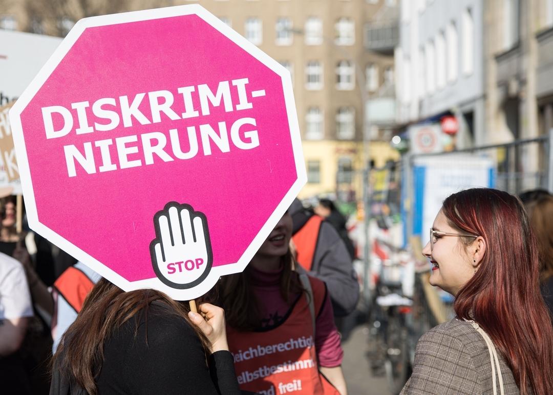 Symbolbild: "Diskriminierung Stop" steht auf dem Schild einer Teilnehmerin auf einer Demonstration. 