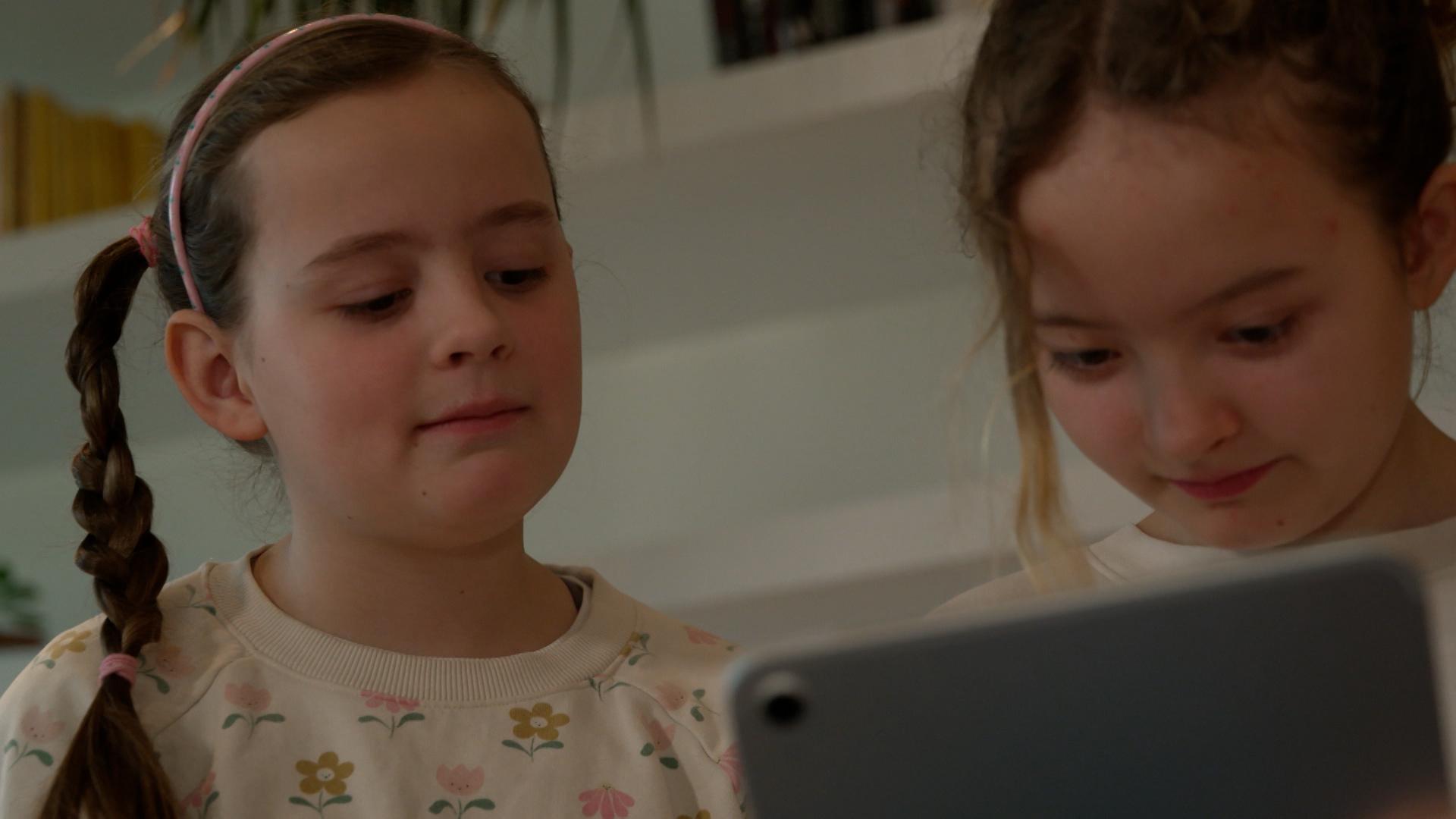 Zwei Mädchen schauen auf ein Tablet