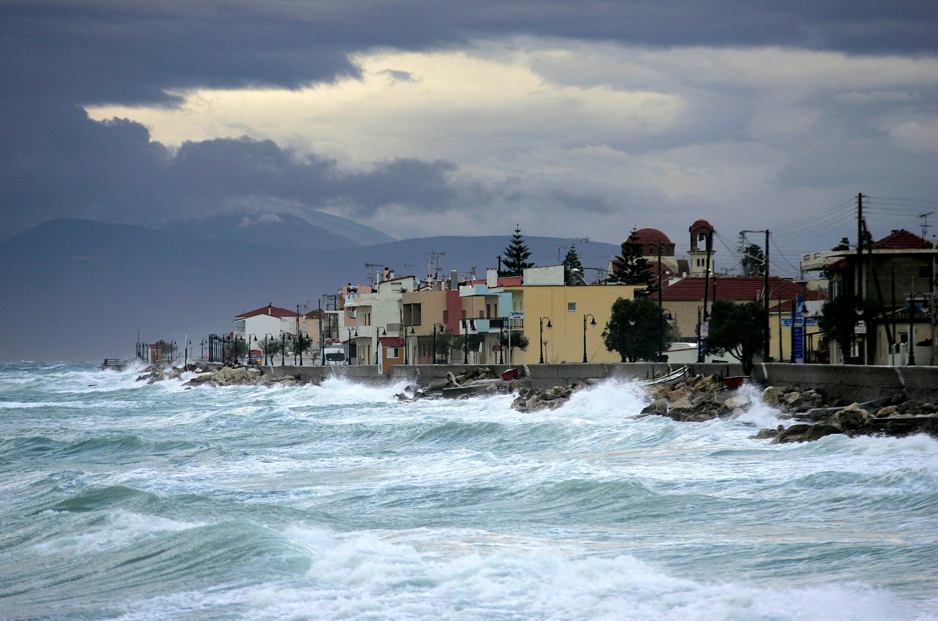 Symbolbild: Wellen schlagen an die Küste eines griechischen Ortes