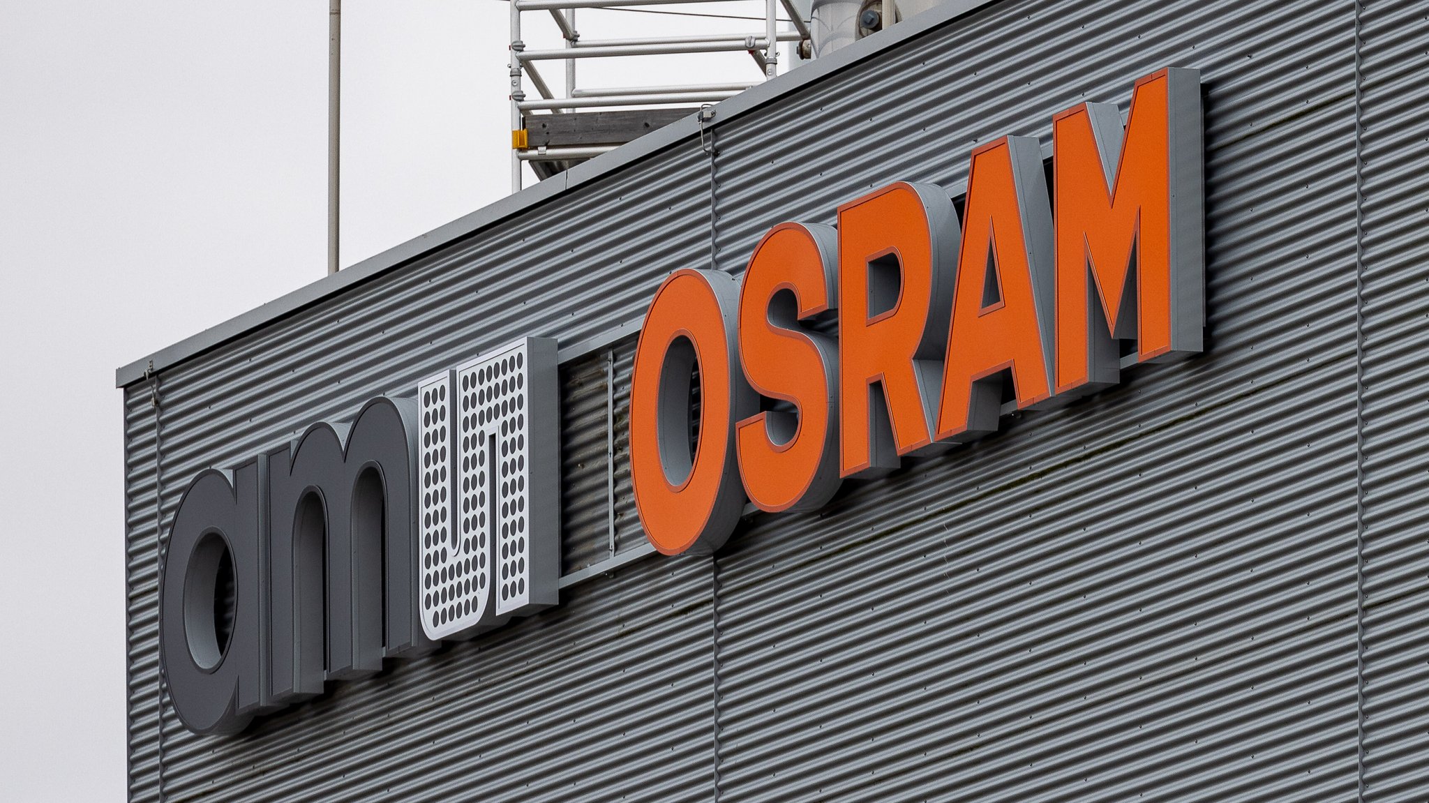 Das Firmenlogo "ams OSRAM" an einer Metallfassade | Bild: picture alliance / Eibner-Pressefoto | Eibner-Pressefoto/Ardan Fuessman Das Firmenlogo "ams OSRAM" an einer Metallfassade