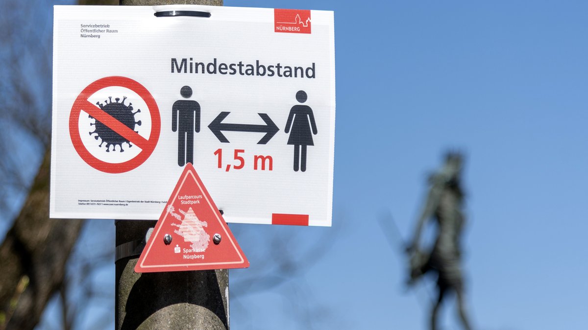 Hinweisschild zum Mindestabstand wegen der Coronakrise im Stadtpark. Nürnberg,