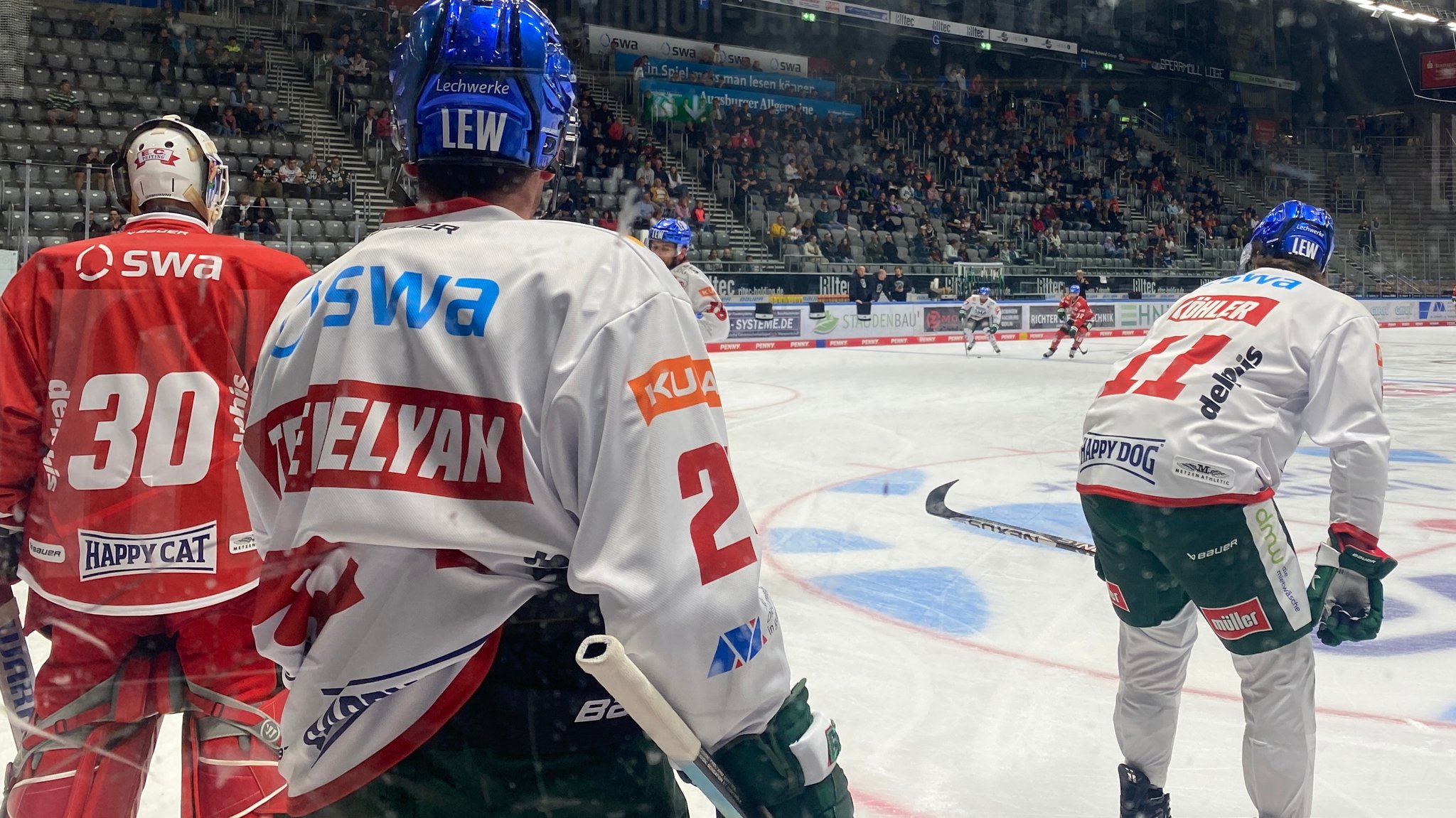 Augsburger Eishockeyspieler beim Training auf dem Eis. Im Hintergrund Fans auf der Tribüne.