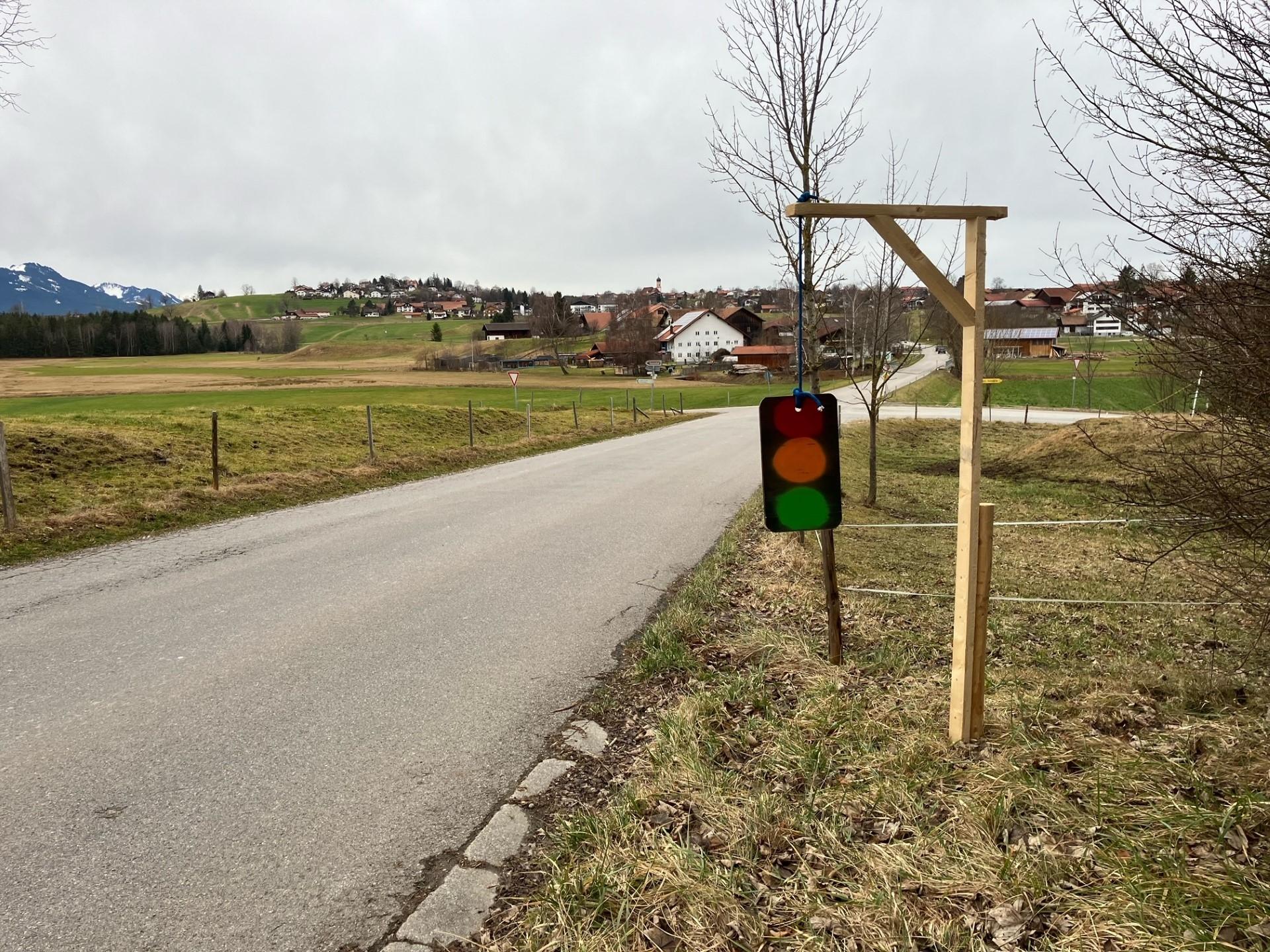 Eine Holzkonstruktion, die einen Galgen darstellt, an dem eine Ampel aufgehängt ist.