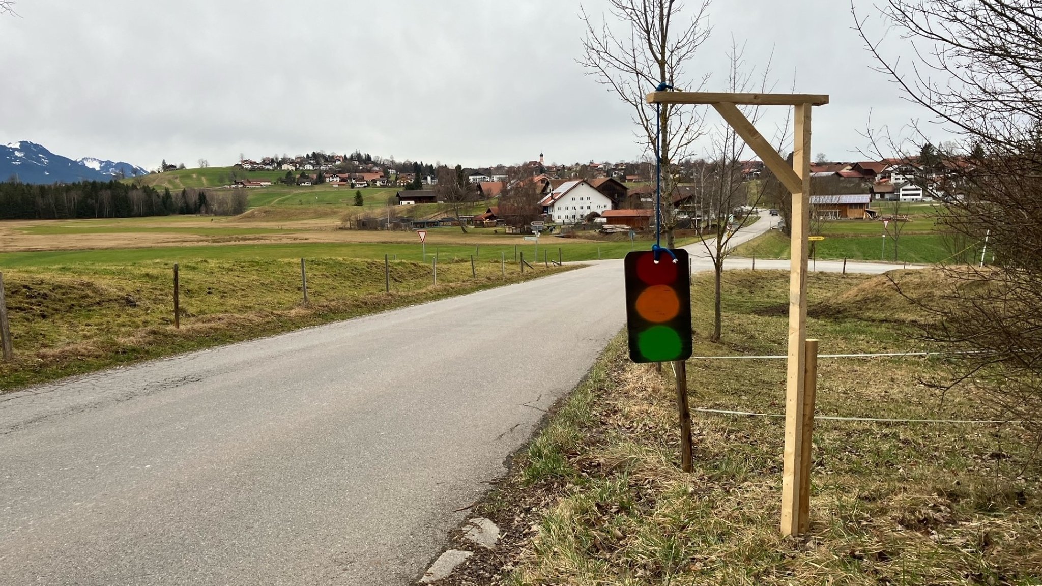 Eine Holzkonstruktion, die einen Galgen darstellt, an dem eine Ampel aufgehängt ist.